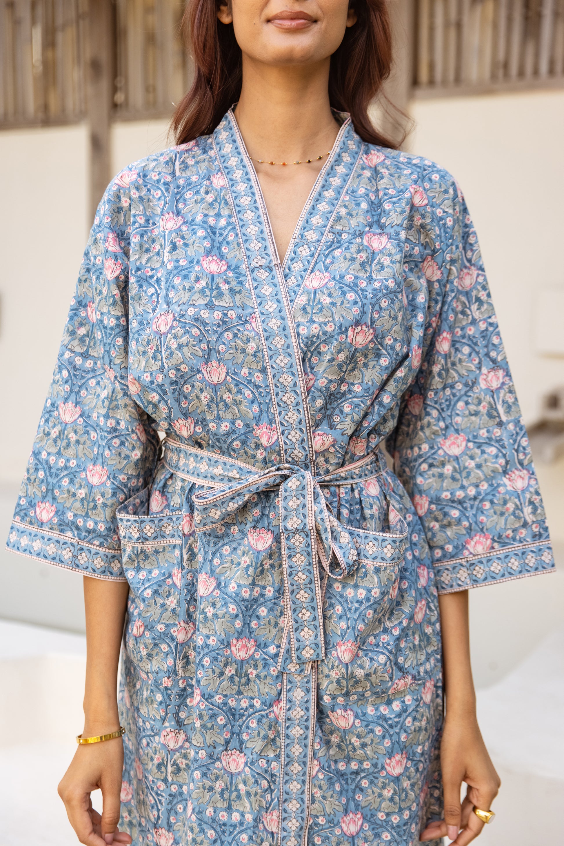 Woman in dusty blue robe enjoying relaxed morning setting