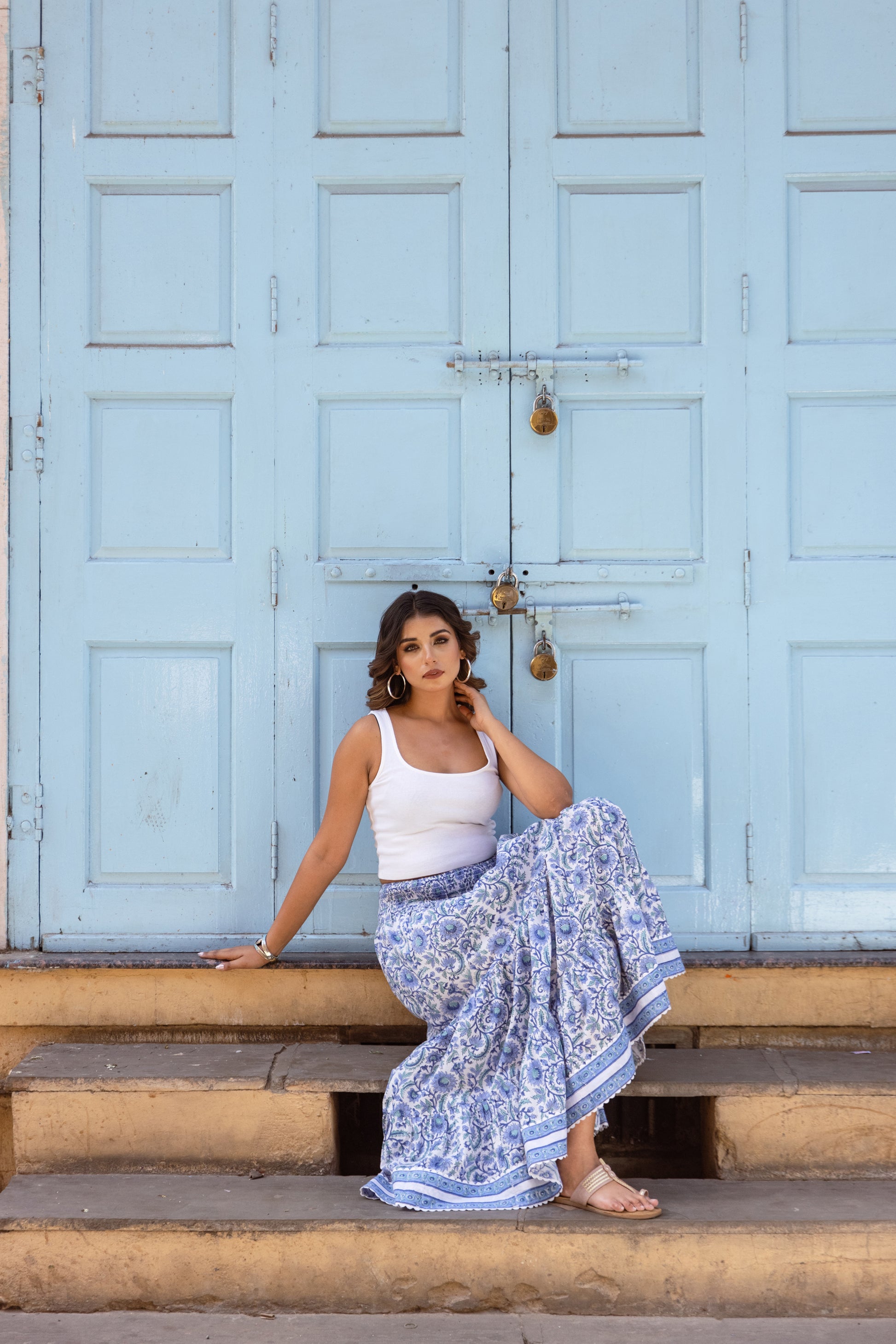 Woman sitting in an azure blue block print summer skirt