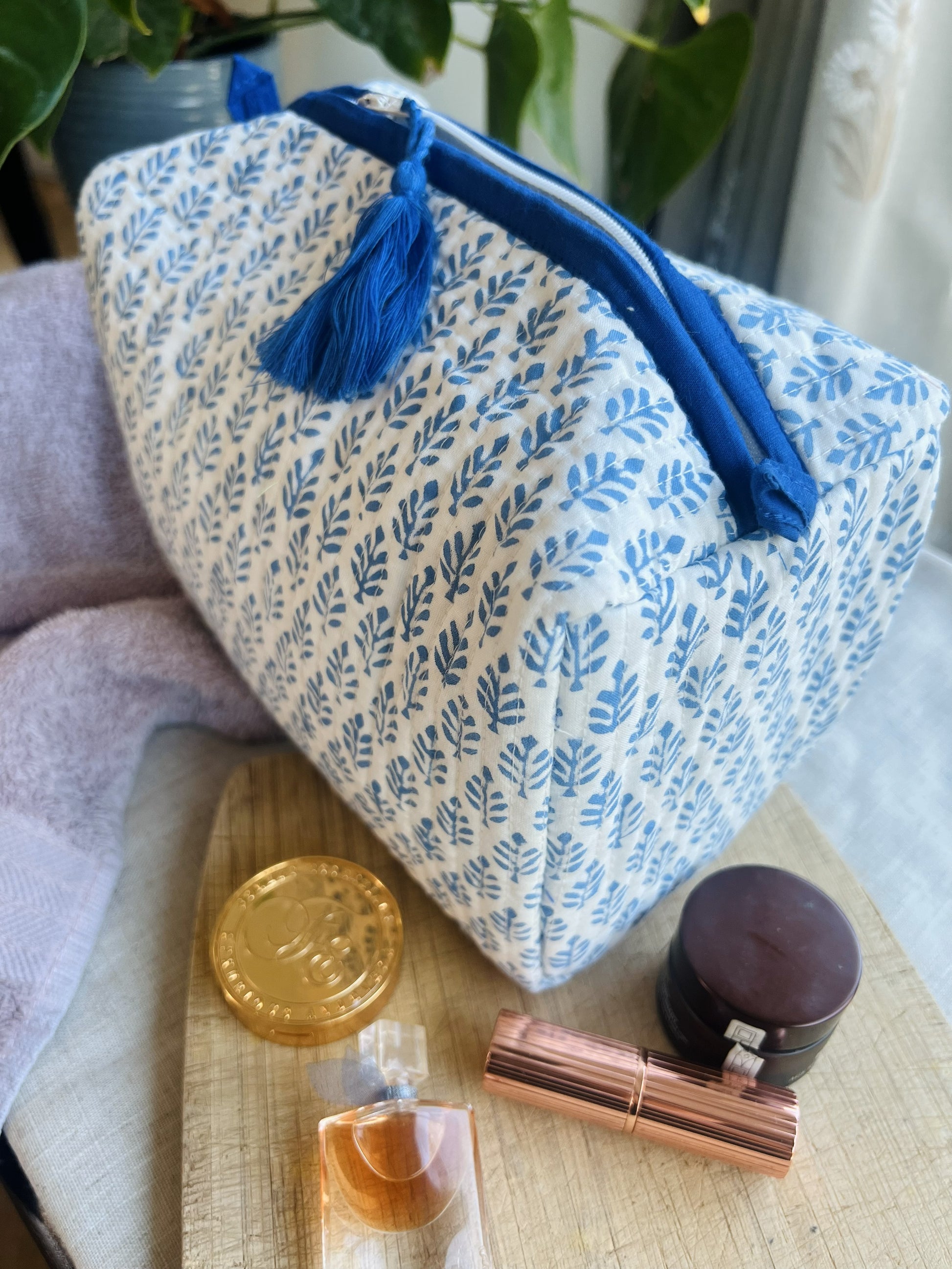 Quilted cotton washbag with waterproof lining and internal pockets.