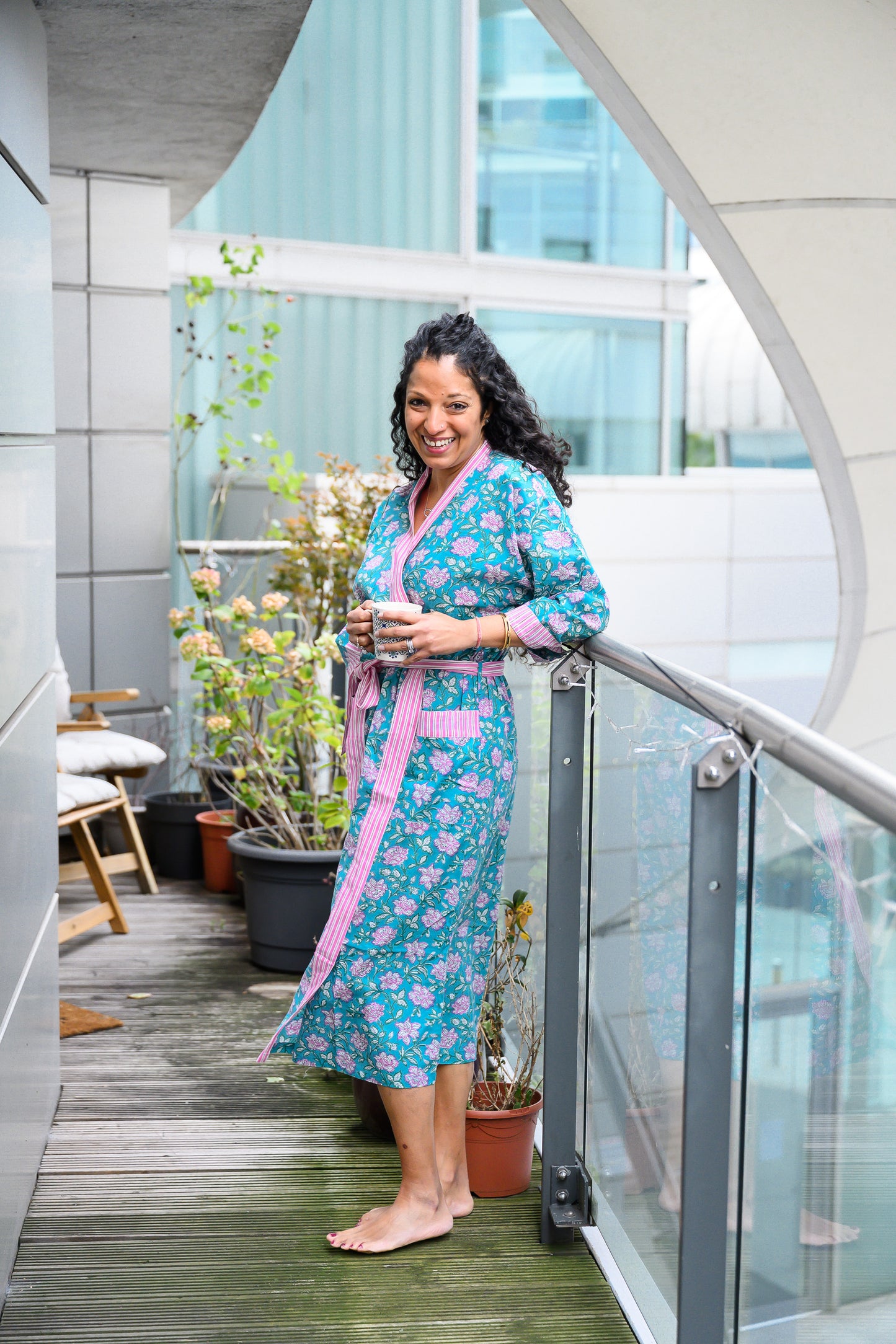 Woman on balcony wearing robe, relaxed pose