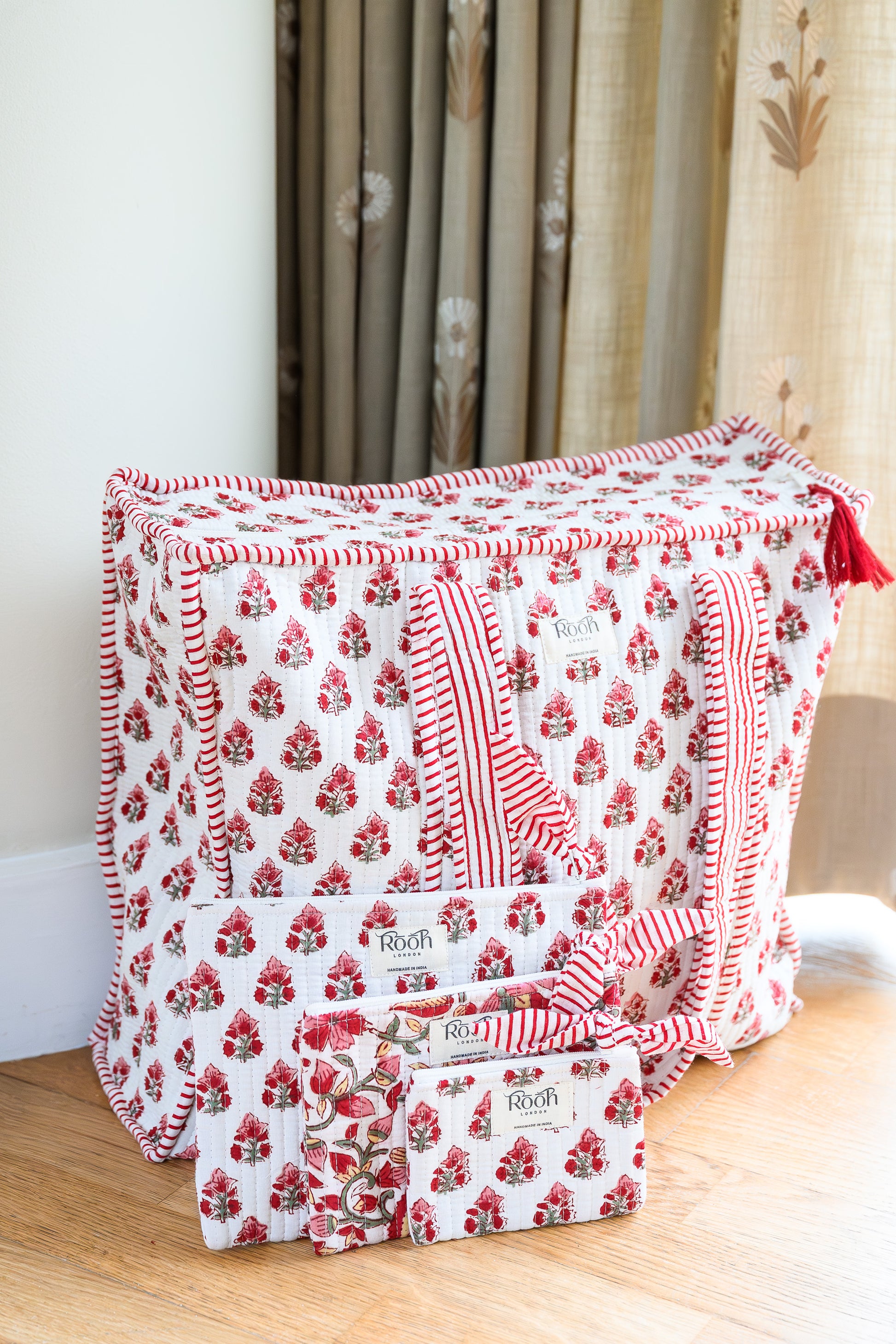 Set of three Crimson Bloom floral quilted cotton pouches.
